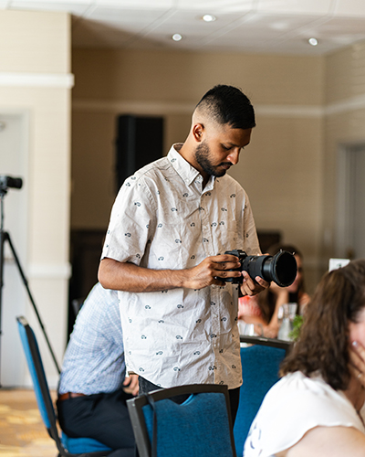 Josh Bud taking photographs at an event with his camera captured by Darkstrand Visuals