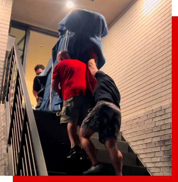 Experienced piano movers in Plano carrying piano upstairs