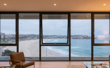 A stylish living area connected to the outdoors with large windows installed using luxury window system services in Sydney. and Belgium and Belgium