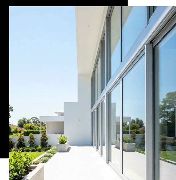 A construction supervisor inspects frame alignment before fitting an aluminum window system into a modern Melbourne home.