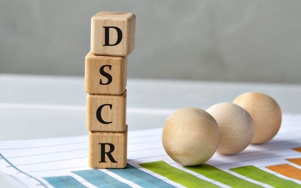 Real estate investor reviewing property documents with financial projections on screen