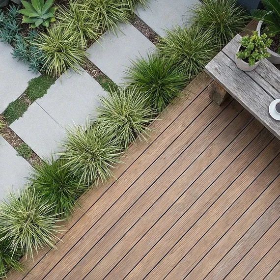 A landscape design displaying a welcoming backyard space with turf, plants, and seating.