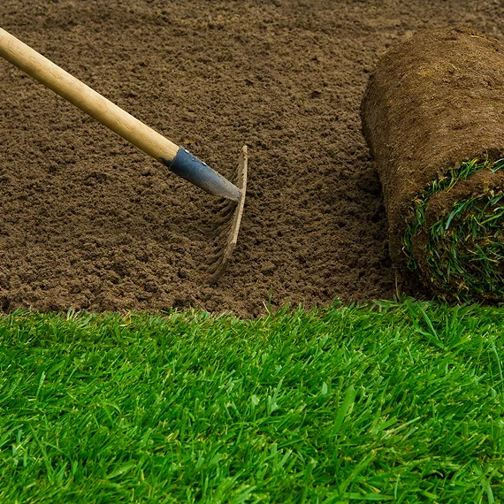 A team trimming shrubs and shaping garden borders as part of lawn & landscaping services for a suburban home.