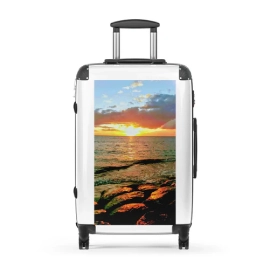 A traveler rolling a suitcase featuring photo printing on luggage through an airport terminal.