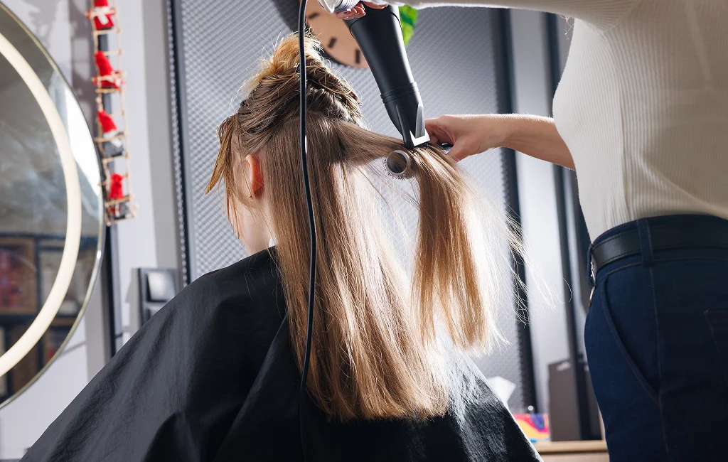 A stylist performs hair styling in Vero Beach on a client.



