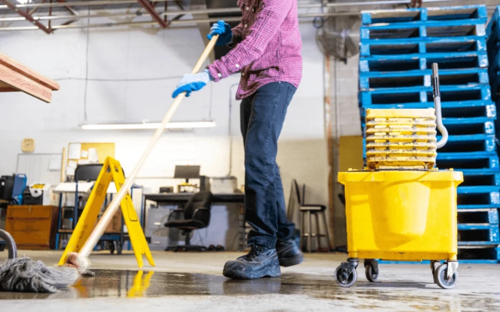 Industrial team performing garage cleaning services in Edmonton inside a commercial vehicle bay.