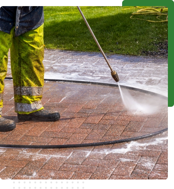 Oil stains being lifted during driveway pressure wash in Edmonton.