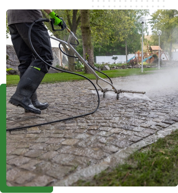 Crew applying pressure washing services to remove grime from a commercial driveway.