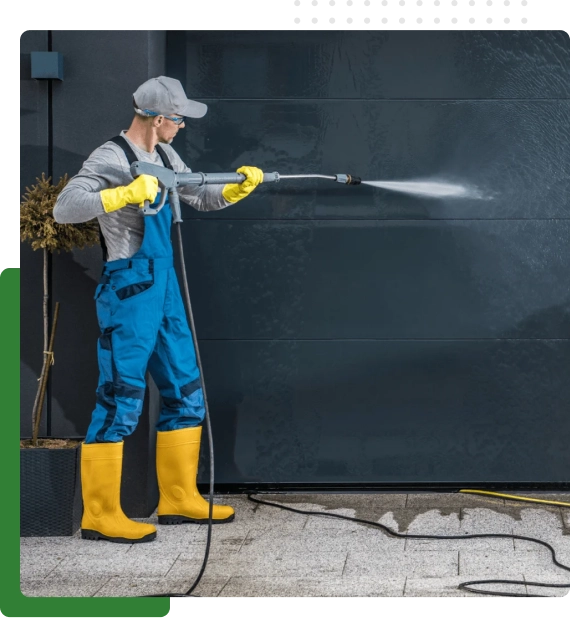 Exterior wall being cleaned using building pressure washing services in Edmonton equipment.