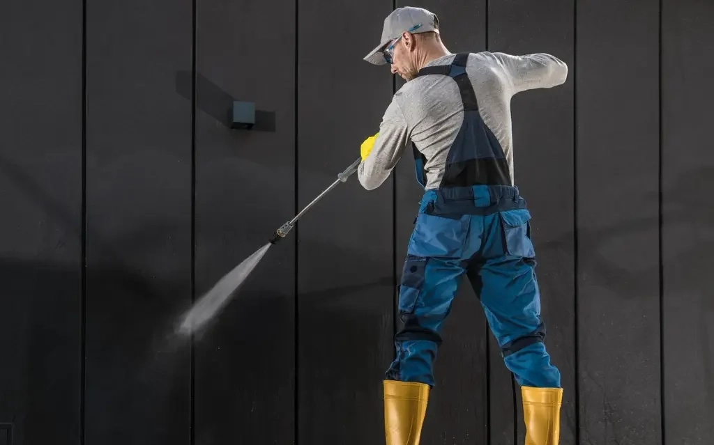 Technicians performing building pressure washing services in Edmonton on a commercial facade.