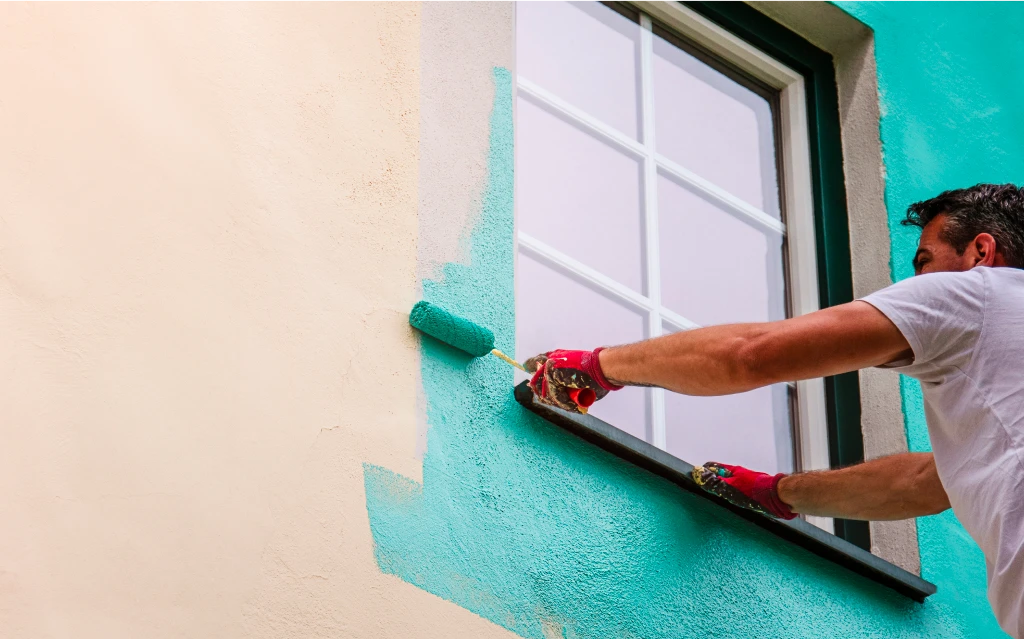 Exterior painting Calgary specialists refreshing a stucco and brick residential facade.