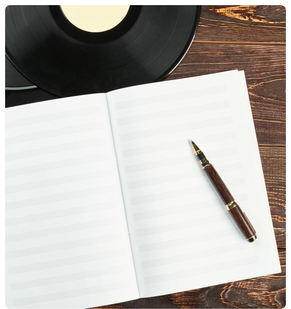 A workshop table covered with notebooks and sheet music during songwriting courses and workshops.