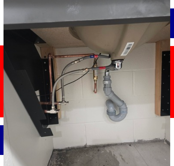 A technician providing plumbing services in a Windsor Park home with older piping.