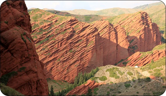 Travelers climbing mountain ridges on Kyrgyzstan hiking tours