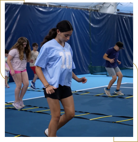 A group of children enjoying a tennis academy for kids lesson with a coach in Burlington.