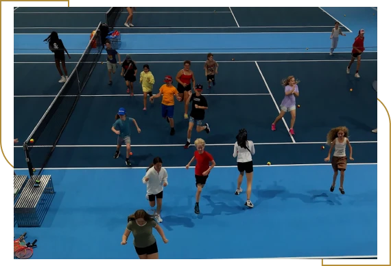 A group of children enjoying a tennis academy for kids lesson with a coach in Burlington.