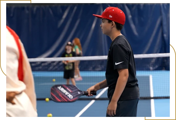 A group of children enjoying a tennis academy for kids lesson with a coach in Burlington.