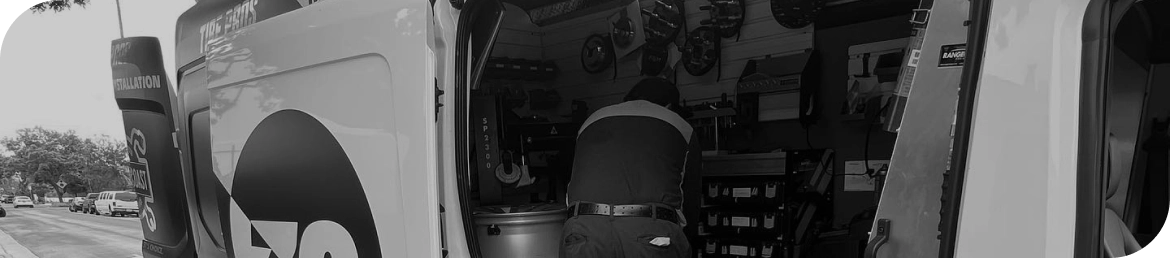 Mobile tire installation van servicing vehicle in Los Angeles parking lot