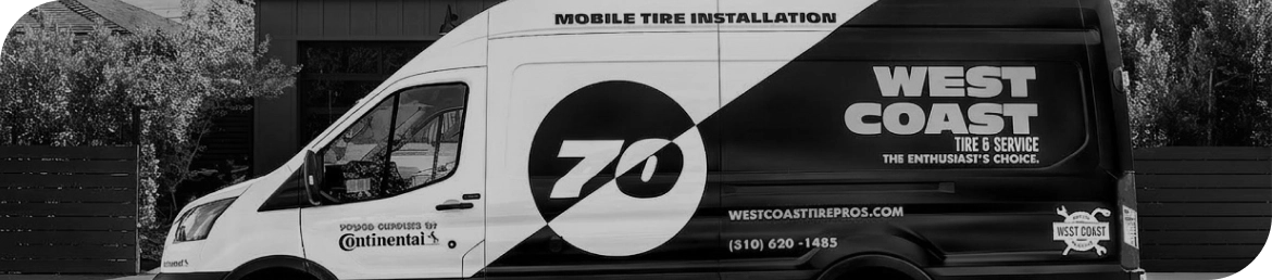 Mobile tire installation van servicing vehicle in Los Angeles parking lot