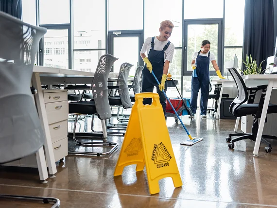 Professional cleaner sanitizing a modern office workspace — commercial cleaning services
