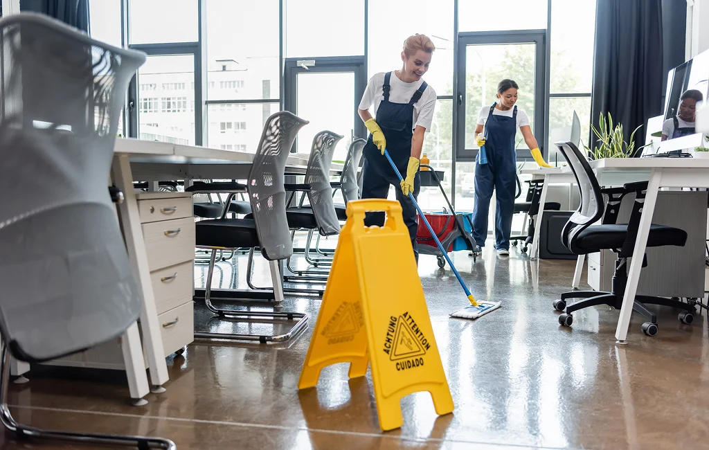 Professional cleaner sanitizing a modern office workspace — commercial cleaning services
