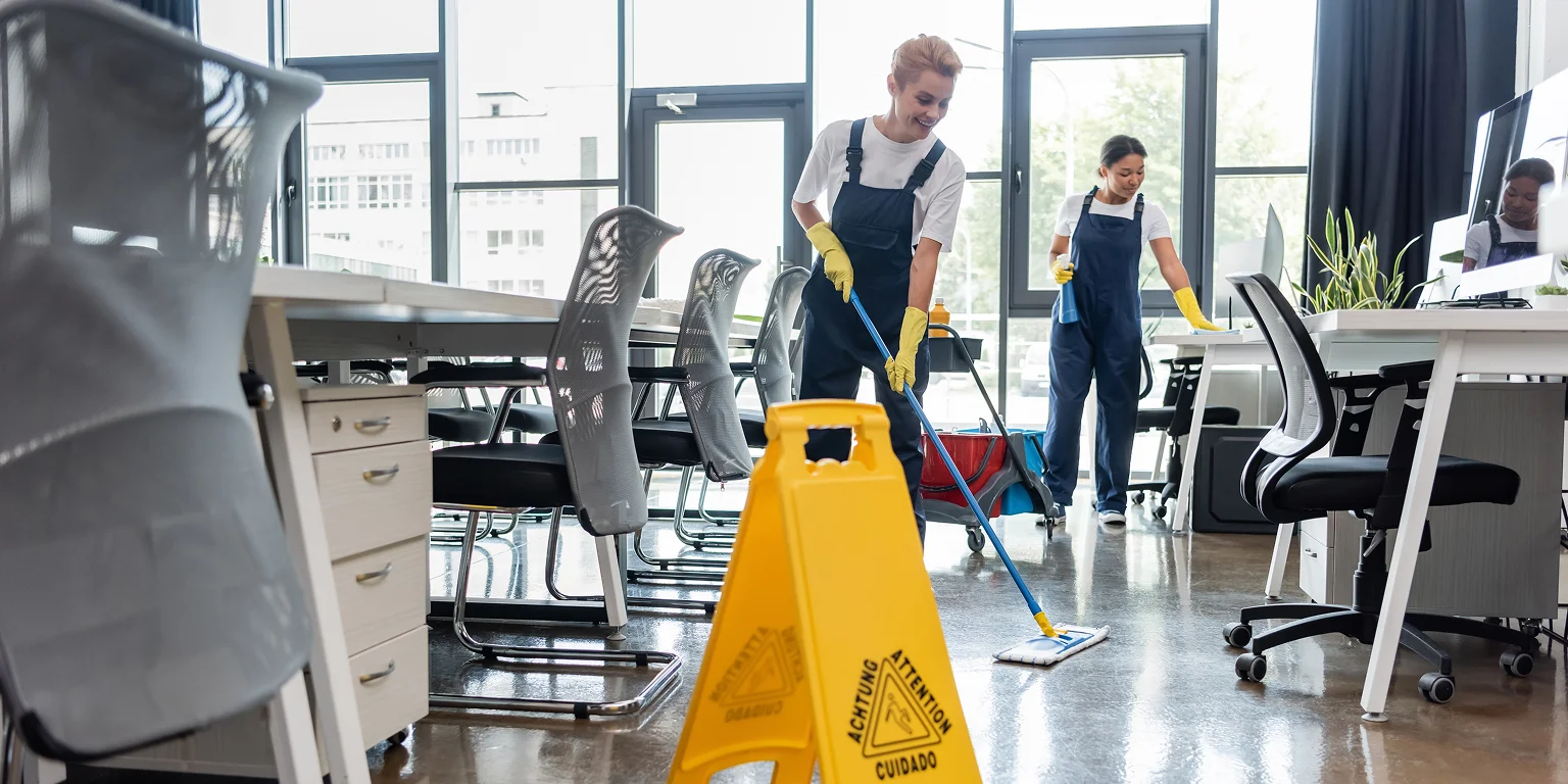 Professional cleaner sanitizing a modern office workspace — commercial cleaning services