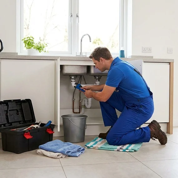 Plumber stopping a water leak at the source