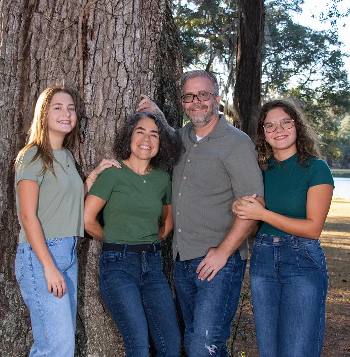 A child laughing during family photography surrounded by oak trees.